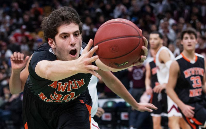A basketball player in a number 30 jersey stretches for a loose ball in front of a packed crowd