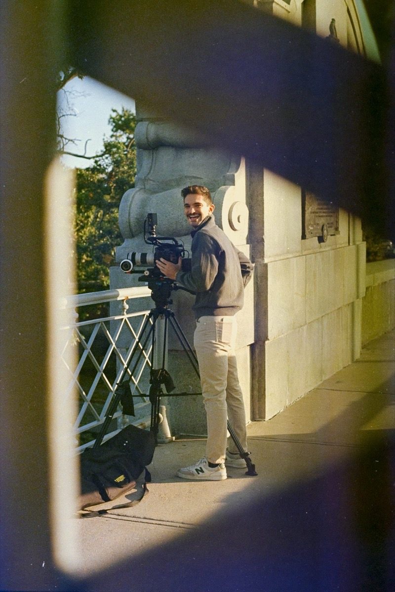 Michael Rotiroti smiling beside his cinema camera on a tripod
